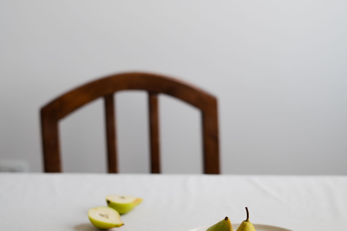 A minimal table setting with pears on a white linen tablecloth